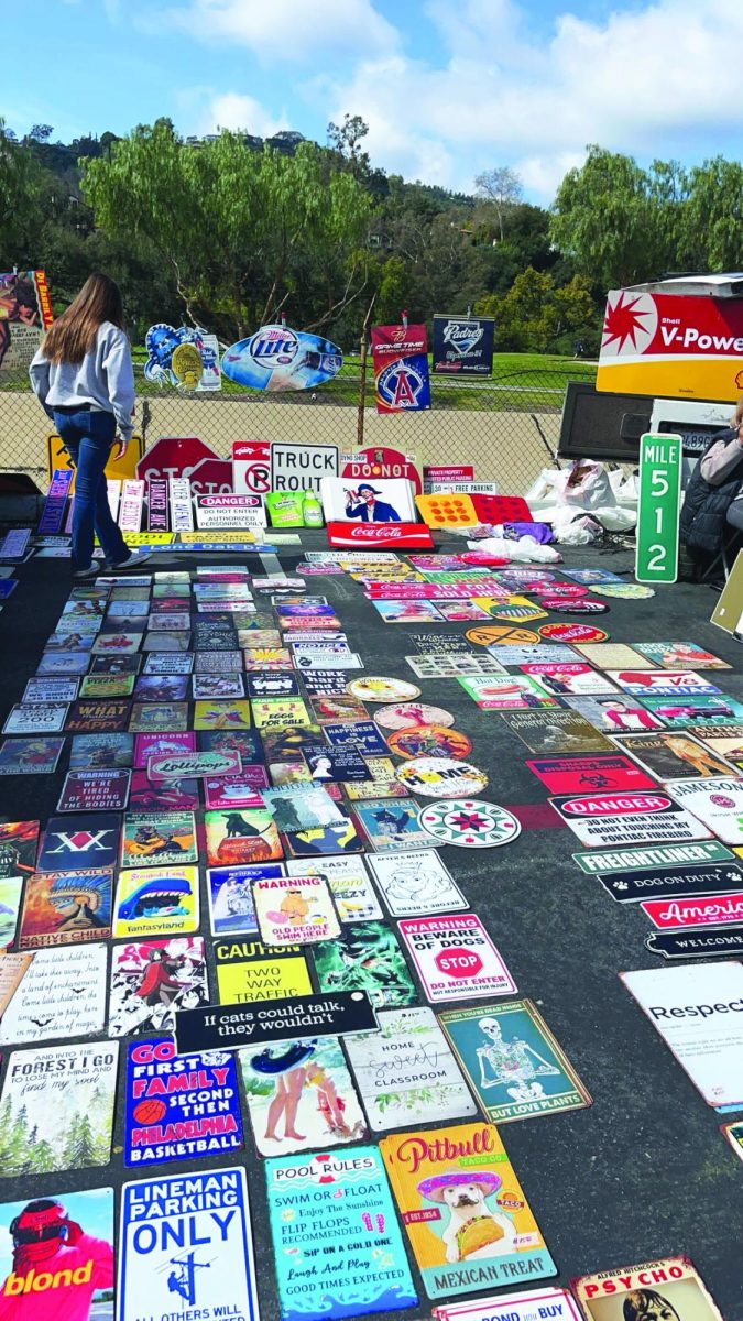 Rae Sirota-Foster '25 enjoys the Rose Bowl Flea Market by browsing through the vibrant signs for sale. She bought a vintage "Hollywood Boulevard" sign. 