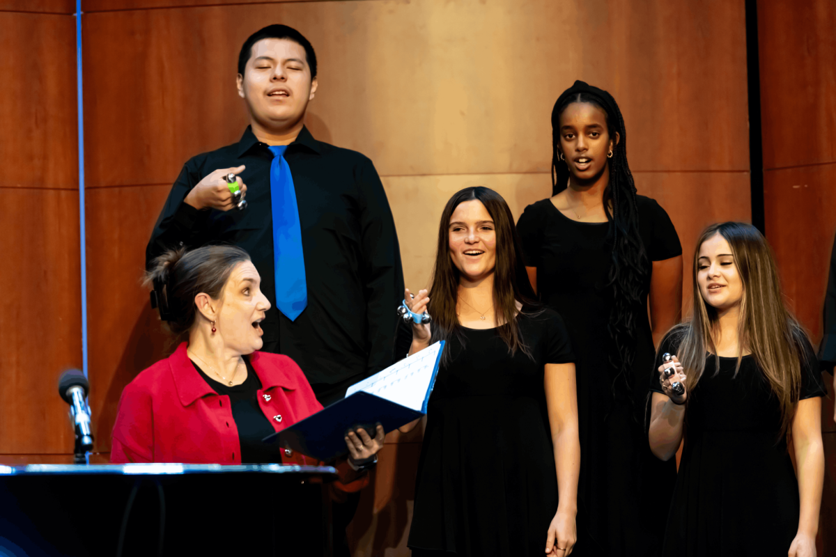 SUPPORTING STUDENTS: Choir director Amy Rolniak leads members of the Concert Choir during the “Jingle All the Way” winter concert in the Carpenter Theatre.

