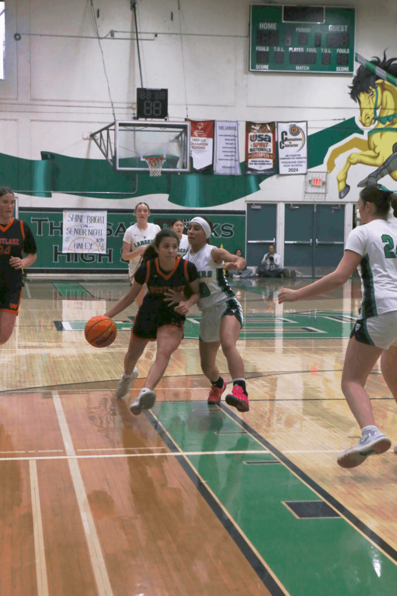 Olivia Elsokary '28 dribbles past a defender on her way to the basket in a home game against Thousand Oaks High School on January 12.